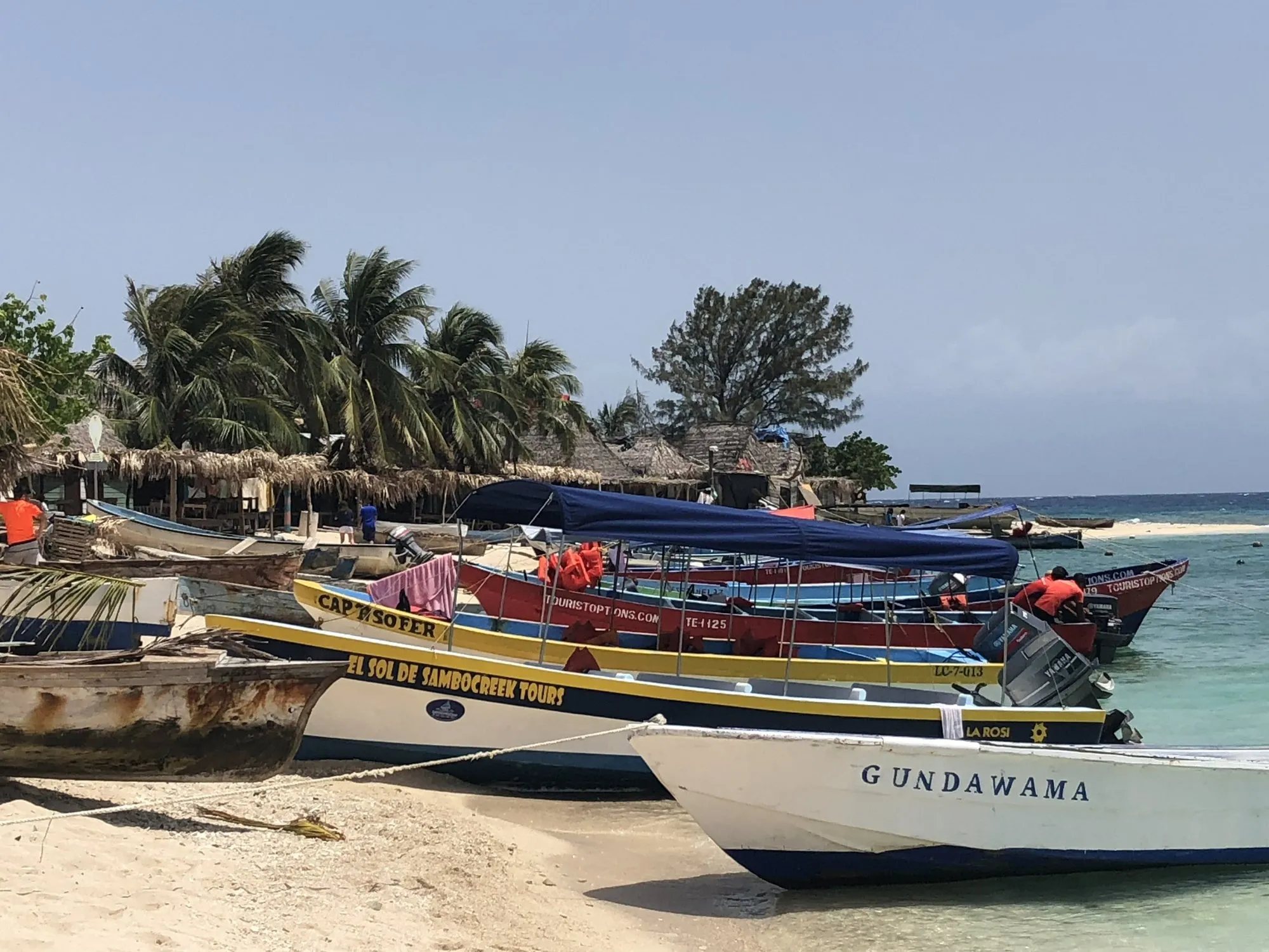 Colorful wooden boats on a Caribbean beach at Cayos Cochinos, Honduras.